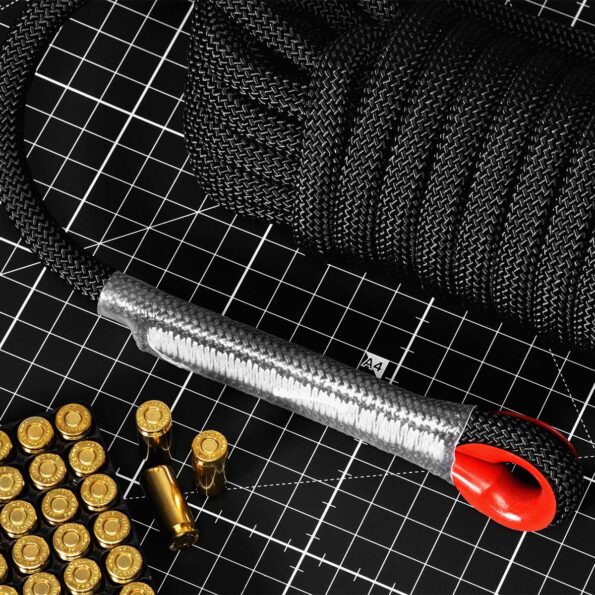 Close-up of black 10 mm SAINT static rope with reinforced red carabiner eyelet and protective sleeve, coiled on tactical grid mat beside ammunition
