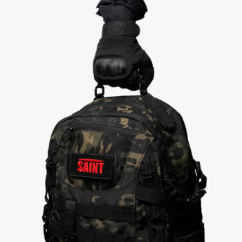 Dark camouflage SAINT tactical backpack held by reinforced top handle
